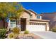 Inviting home with a two-car garage, mature tree, and rock landscaping in the front yard at 304 Iron Summit Ave, North Las Vegas, NV 89031
