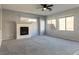 Cozy living room featuring a fireplace, plush carpet, and natural light streaming through the windows at 304 Iron Summit Ave, North Las Vegas, NV 89031