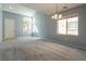 Bright living room with a vaulted ceiling, large windows, neutral carpet, and a chandelier at 304 Iron Summit Ave, North Las Vegas, NV 89031