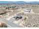 An aerial view of desert land, neighborhood homes, and mountain views in the background at 3050 Oakridge Ave, Pahrump, NV 89048