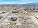 An aerial view of desert land, neighborhood homes, mountain views, and the property with a pool and horse property at 3050 Oakridge Ave, Pahrump, NV 89048
