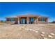 Back of desert home featuring covered patio and stone walkway at 3050 Oakridge Ave, Pahrump, NV 89048