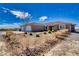 Tan home featuring an attached two car garage, desert landscaping and covered entryway at 3050 Oakridge Ave, Pahrump, NV 89048