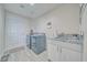 Practical laundry room with gray washer/dryer, utility sink, and door access at 3050 Oakridge Ave, Pahrump, NV 89048