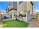 Backyard featuring artificial turf, brick paver patio, privacy wall, and hanging egg chairs at 3354 Via Strada St, Henderson, NV 89044