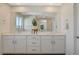 Modern bathroom with double sinks, a large mirror, white cabinets, and minimalist decor at 3354 Via Strada St, Henderson, NV 89044