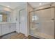 Bright bathroom featuring a glass shower, and a modern single sink vanity with wood look flooring at 3354 Via Strada St, Henderson, NV 89044