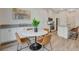 Open dining area with a marble table and modern chairs, adjacent to a stylish kitchen with stainless appliances at 3354 Via Strada St, Henderson, NV 89044