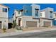 Striking exterior view of modern home with a two-car garage, accented by a red door and fresh landscaping at 3354 Via Strada St, Henderson, NV 89044