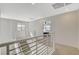 Bright upstairs hallway featuring modern railing, carpet, and access to bedrooms and other living spaces at 3354 Via Strada St, Henderson, NV 89044