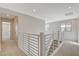Bright hallway showcasing modern railing, fresh paint, and plush carpet, leading to other areas of the home at 3354 Via Strada St, Henderson, NV 89044