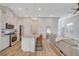 Open-concept living room boasts a kitchen with white cabinets, a large island and stainless steel appliances at 3354 Via Strada St, Henderson, NV 89044