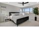 Bright main bedroom featuring a black bed frame, corner windows with neighborhood views, and a minimalist design at 3354 Via Strada St, Henderson, NV 89044