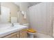 Well-lit bathroom with a white sink and vanity, toilet, shower with curtain and a wooden toilet seat at 3660 Renovah St # 201, Las Vegas, NV 89129