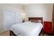 Bedroom with a queen bed, sliding door closet, soft lighting, and a bright red accent chair at 3660 Renovah St # 201, Las Vegas, NV 89129