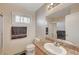 A well-lit bathroom featuring a vanity, toilet, mirror, shower with glass doors, and window at 3747 Gulliver St, Las Vegas, NV 89115