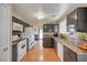 Cozy kitchen featuring white appliances, wooden floors, dark cabinetry and plenty of natural light at 3747 Gulliver St, Las Vegas, NV 89115