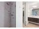 View of a sleek walk-in shower with rainfall showerhead and marble tile, adjacent to a modern vanity at 4135 N Durango Dr, Las Vegas, NV 89129
