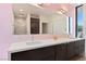 Bathroom featuring a double vanity with a quartz countertop and a mirror, complemented by pink walls and a view to the outside at 4135 N Durango Dr, Las Vegas, NV 89129