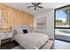 Well-lit bedroom with patterned accent wall, a comfortable bed, and a view to the outside at 4135 N Durango Dr, Las Vegas, NV 89129