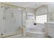 Luxurious bathroom featuring a glass-enclosed shower, a soaking tub, and elegant marble accents at 4339 Grey Spencer Dr, Las Vegas, NV 89141
