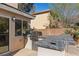 An outdoor kitchen features a built-in grill and tiled bar with brick flooring at 4339 Grey Spencer Dr, Las Vegas, NV 89141