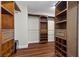 Spacious walk-in closet with custom built-in shelves, drawers, and hardwood floors providing ample storage space at 4339 Grey Spencer Dr, Las Vegas, NV 89141