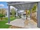 Stylish backyard with a pergola-covered seating area, outdoor lighting, and lush landscaping with palm trees at 4345 N Dapple Gray Rd, Las Vegas, NV 89129