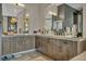 Bright bathroom featuring dual sinks, wooden cabinets, and stylish lighting fixture at 4345 N Dapple Gray Rd, Las Vegas, NV 89129