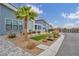 The front yard boasts a lush xeriscape design, combining rocks, greenery, and a beautiful palm tree for curb appeal at 4345 N Dapple Gray Rd, Las Vegas, NV 89129
