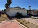 View of a backyard featuring a covered patio and a small desert landscape under a bright, clear sky at 4442 Bennett Dr, Las Vegas, NV 89121