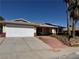 Single-story home with a two-car garage, desert landscaping and a walkway to the front door at 4442 Bennett Dr, Las Vegas, NV 89121