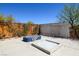 Secluded backyard with a modern glass rock fire pit, outdoor sofa, and privacy fencing at 5014 Thunder River Cir, Las Vegas, NV 89148