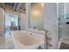 Close-up of modern white bathtub with sleek fixtures and adjacent glass-enclosed shower in bright bathroom at 5014 Thunder River Cir, Las Vegas, NV 89148