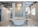Bright bathroom featuring a standalone tub, marble floors, and modern fixtures beneath a unique overhead lighting fixture at 5014 Thunder River Cir, Las Vegas, NV 89148