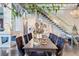 Elegant dining area with modern chandeliers, a large stone countertop, and a staircase with glass panels, perfect for gatherings at 5014 Thunder River Cir, Las Vegas, NV 89148