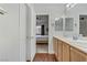 A bright bathroom featuring double sinks, light wood cabinets, and an open doorway to bedroom at 5465 Cardinal Ridge Ct # 103, Las Vegas, NV 89149