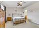 A cozy bedroom with a wrought iron bed frame, wooden dresser, and ceiling fan at 5465 Cardinal Ridge Ct # 103, Las Vegas, NV 89149