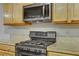 Close-up shot of a modern gas range and microwave in a clean kitchen at 5465 Cardinal Ridge Ct # 103, Las Vegas, NV 89149