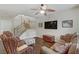 Cozy living room featuring a staircase, woven chairs, and a television mounted on the wall at 5465 Cardinal Ridge Ct # 103, Las Vegas, NV 89149