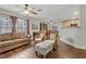 Comfortable living room featuring a ceiling fan, plush sofa, and woven chairs for relaxed lounging at 5465 Cardinal Ridge Ct # 103, Las Vegas, NV 89149