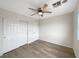 Bright bedroom featuring a ceiling fan, wood floors and a closet with white doors at 6228 Grace Mountain St, Las Vegas, NV 89115