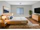 Cozy bedroom featuring a natural wood bed frame, neutral bedding, and a modern dresser, all on wood floors at 6228 Grace Mountain St, Las Vegas, NV 89115
