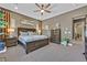 Primary bedroom featuring a ceiling fan, warm neutral tones, carpet flooring, and elegant furniture at 6232 Lautman Ridge Ct, Las Vegas, NV 89141