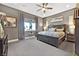 Comfortable bedroom featuring a ceiling fan, gray walls and carpet, and a large window at 6232 Lautman Ridge Ct, Las Vegas, NV 89141