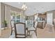 Dining area with glass table, upholstered chairs, elegant pendant lighting, and seamless access to kitchen at 6232 Lautman Ridge Ct, Las Vegas, NV 89141