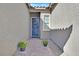 Inviting front entrance with a blue door, potted flowers, and decorative wreath at 6232 Lautman Ridge Ct, Las Vegas, NV 89141
