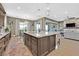 Open concept kitchen with granite island, stainless steel sink, dining area, and seamless access to living room at 6232 Lautman Ridge Ct, Las Vegas, NV 89141