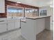 Bright kitchen with white cabinets, island, and a view of the backyard at 7181 Pleasant View Ave, Las Vegas, NV 89147
