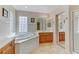This bright bathroom features dual sinks, soaking tub, glass shower, and tile floors at 7609 Trimming Ct, Las Vegas, NV 89149